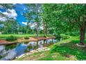 Scenic backyard view with a tranquil pond and lush green surroundings at 456 Colonial Trace Dr. # 13-E, Longs, SC 29568