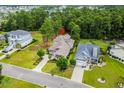 Stunning aerial view showcasing the home's location surrounded by lush greenery and a serene lake at 496 Starlit Way, Myrtle Beach, SC 29579