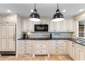 Beautiful kitchen showcasing custom cabinets, black appliances, and stylish pendant lighting at 571 Fernwood Rd., Murrells Inlet, SC 29576