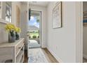 Bright entryway with wood floors, decorative mirror, and front door with lots of natural light at 5716 Lombardia Circle, Myrtle Beach, SC 29579