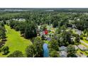 Aerial view of a home nestled among lush greenery and a pond in a serene neighborhood at 6576 Pebble Beach Crescent, Myrtle Beach, SC 29588
