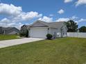 Side view of the home displaying the driveway, two car garage, and fenced in yard at 671 American Beech St., Loris, SC 29569