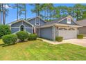 Charming home featuring a two-car garage, manicured lawn and low foundation shrubbery at 890 Knoll Dr., Little River, SC 29566