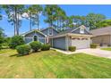 Charming home featuring a two-car garage, manicured lawn and low foundation shrubbery at 890 Knoll Dr., Little River, SC 29566