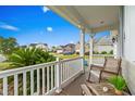 Inviting front porch view with comfortable seating, a white railing, and lush greenery at 908 Ashbourn Ct., Murrells Inlet, SC 29576