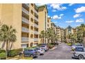 A condo complex with multiple floors featuring private balconies and ample parking at 139 S Dunes Dr. # 304, Pawleys Island, SC 29585