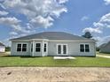 Exterior view of home showing a spacious backyard with a patio and large windows for ample natural light at 189 Norris Ln, Loris, SC 29569