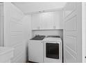 Convenient laundry room featuring white cabinets, washer and dryer units at 2308 Seaseeker Ln., Myrtle Beach, SC 29577