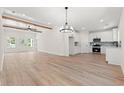 Open-concept living room featuring a kitchen, ceiling beams, chandelier, and wood-look flooring at 2426 Park St., North Myrtle Beach, SC 29582