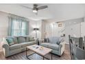 Bright and airy living room with two comfortable sofas, ceiling fan, and staircase at 403 71St Ave. N # 5, Myrtle Beach, SC 29572