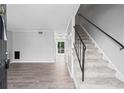 Bright living room featuring wood floors, neutral paint, a carpeted staircase, and natural light streaming through the doorway at 4115 Little River Rd. # 1-E, Myrtle Beach, SC 29577