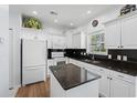 Bright kitchen featuring white cabinets, modern appliances, and black granite countertops at 503 20Th Ave. N # 9D, North Myrtle Beach, SC 29582