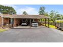 Wide view of the brick two car carport, with a picnic table, and lush green surrounding yard at 6204 Sancindy Ln., Myrtle Beach, SC 29572