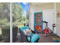 Inviting screened-in patio with exercise bike, garden views, and comfortable chair with colorful pillows at 6253 Catalina Dr. # 1711, North Myrtle Beach, SC 29582