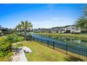 Backyard with wrought iron fence looks out over the community pond with fountains, with neighboring houses in the background at 6706 Ocean Breeze Loop, Myrtle Beach, SC 29572