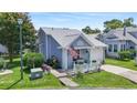 Well-maintained single-story home with blue siding, a tidy front lawn, and a charming white picket fence at 110 Cambridge Circle, Myrtle Beach, SC 29577