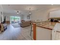 Open-concept living room next to the modern kitchen with seating at countertop at 110 South Shore Blvd. # 203, Longs, SC 29568