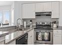 Well-lit kitchen featuring granite countertops, stainless steel oven, modern fixtures and white cabinets for a clean aesthetic at 1100 Possum Trot Rd. # F218, North Myrtle Beach, SC 29582