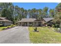 Charming single-story home featuring a well-manicured lawn and inviting curb appeal nestled amongst the trees at 137 Hickory Dr., Conway, SC 29526