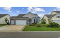 Inviting single-story home showcasing a well-kept lawn, brick accents, and an attached garage at 138 Copper Leaf Dr., Myrtle Beach, SC 29588