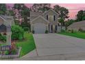 Charming two-story home with front-facing garage and an extra long driveway situated on a manicured lawn at 161 Barclay Dr., Myrtle Beach, SC 29579