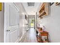 Inviting hallway with wood-look floors, white doors and decorative shelving showcasing a warm and welcoming space at 227 Palm Terrace Loop, Conway, SC 29526
