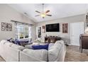 Cozy living room with a large sectional, wood-look floors, vaulted ceilings, and a decorative fireplace at 227 Palm Terrace Loop, Conway, SC 29526