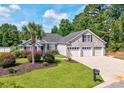 Beautifully landscaped front yard featuring a three-car garage and mature palm trees at 229 Duchess Ct., Myrtle Beach, SC 29588