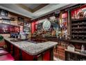 Home bar featuring a granite countertop, custom wood and glass shelving, and eclectic decor at 2450 Marsh Glen Dr. # 112, North Myrtle Beach, SC 29582