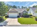 Charming single-story home with a well-manicured lawn, landscaped garden, and attached two-car garage at 3154 Shorecrest Bay Dr., Murrells Inlet, SC 29576