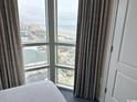 Bedroom view showcasing large windows offering panoramic views of the city and the beautiful coastline at 3601 N Ocean Blvd. # 1139, North Myrtle Beach, SC 29582