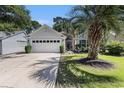 Charming single-story home with a well-manicured lawn, palm tree and an attached two car garage at 4610 Fringetree Dr., Murrells Inlet, SC 29576