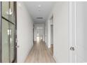Long hallway with light wood floors and white walls, leading to various rooms at 490 Calhoun Falls Dr., Myrtle Beach, SC 29579
