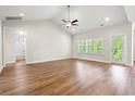 Bright living room with high ceilings, ceiling fan, wood floors, and a patio door at 5004 Shore Breeze Dr., Myrtle Beach, SC 29588