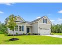 Well-manicured lawn frames this inviting single Gathering home, complete with a two-car garage and charming blue shutters at 5009 Shore Breeze Dr., Myrtle Beach, SC 29588