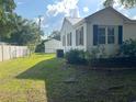 Backyard features a well-maintained lawn, privacy fence, and detached garage with a yellow door at 518 Nowell St., Georgetown, SC 29440
