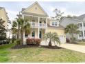 Charming two-story yellow home with double porches and a front yard with palm trees at 821 Falkirk St., Myrtle Beach, SC 29579