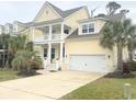 Charming yellow home featuring a double garage, a double porch, and tropical landscaping at 821 Falkirk St., Myrtle Beach, SC 29579