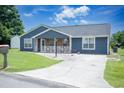 Inviting blue home with a covered porch, bench, and driveway at 890 Holly Sands Blvd., Little River, SC 29566
