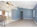 Open-concept living room with wood-look flooring and blue accent wall, leading to kitchen at 890 Holly Sands Blvd., Little River, SC 29566