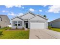 Well-manicured gray home featuring an attached garage, and beautiful landscaping at 1128 Sennema Circle, Myrtle Beach, SC 29588