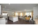 Open-concept living room with a spacious kitchen island, hardwood floors, and bright, neutral decor at 1239 Maxwell Dr., Little River, SC 29566