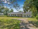 Traditional ranch-style home featuring a spacious front yard with trees and bushes along the front of the property at 12721 Pleasant Hill Dr., Hemingway, SC 29554