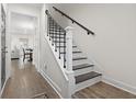 Elegant staircase with dark wood treads, white risers, and black iron railings, leading to the upper level at 1428 Lanterns Rest Rd. # 1428, Myrtle Beach, SC 29579