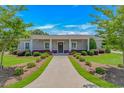 Charming exterior showcasing a well-manicured lawn, lush landscaping, and inviting walkway leading to the front door at 15810 County Line Rd., Andrews, SC 29510
