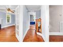 Hallway with light blue walls, with hardwood floors and a staircase with wood railing at 203 Lakeland Dr., Conway, SC 29526