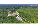 Aerial view of the property highlighting location, mature trees, the home, outbuildings, and surrounding landscape at 2879 Waccamaw Cove, Longs, SC 29568