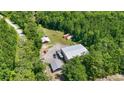 Aerial view of the property showcasing the home, outbuildings, surrounded by mature trees, and a long driveway at 2879 Waccamaw Cove, Longs, SC 29568