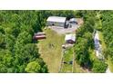 Wide aerial view of the property showcasing mature trees and outbuildings, including a fire pit and storage containers at 2879 Waccamaw Cove, Longs, SC 29568