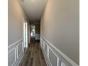 Inviting hallway featuring wood flooring and decorative wainscoting that leads to other rooms at 3139 Tiger Tail Rd., Conway, SC 29526